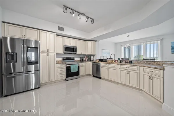 a kitchen with granite countertop white cabinets and stainless steel appliances