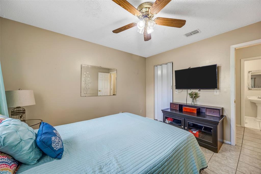 609 King Henry Court Seffner, FL 33584 - Photo 24 of 42 a bedroom with a bed and a flat screen tv