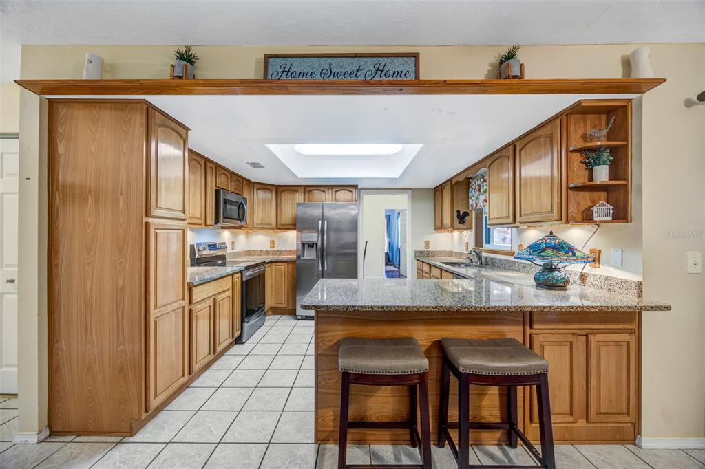 609 King Henry Court Seffner, FL 33584 - Photo 3 of 42 a kitchen with stainless steel appliances granite countertop a sink and cabinets