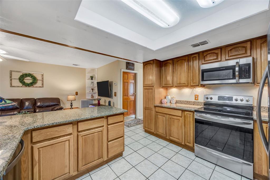 609 King Henry Court Seffner, FL 33584 - Photo 4 of 42 a kitchen with stainless steel appliances granite countertop a stove microwave and cabinets