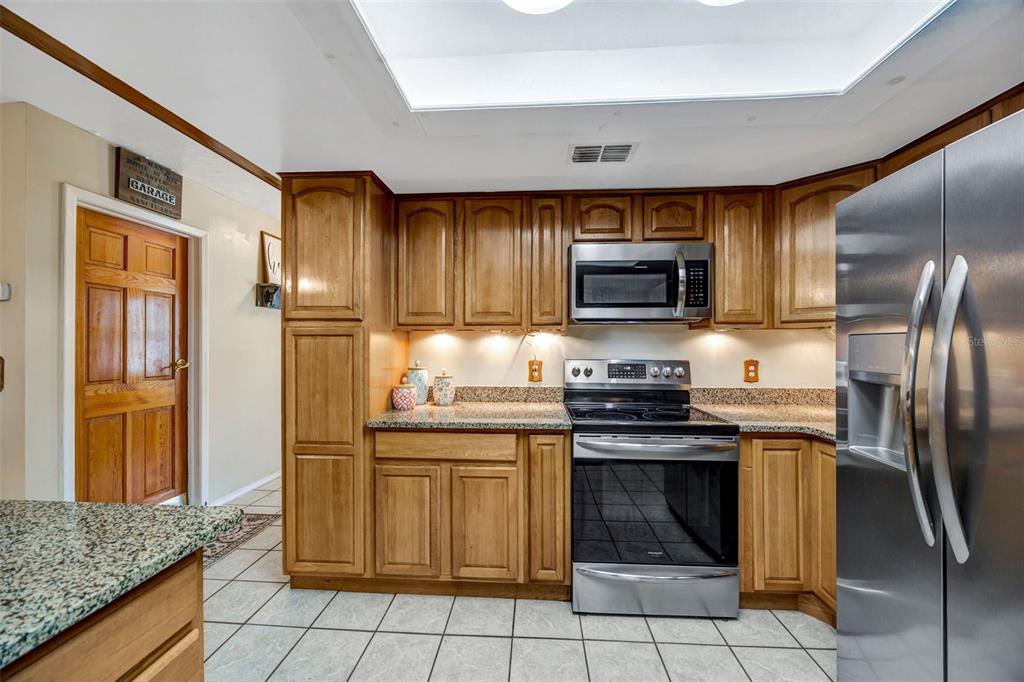 609 King Henry Court Seffner, FL 33584 - Photo 8 of 42 a kitchen with stainless steel appliances granite countertop a stove refrigerator and microwave