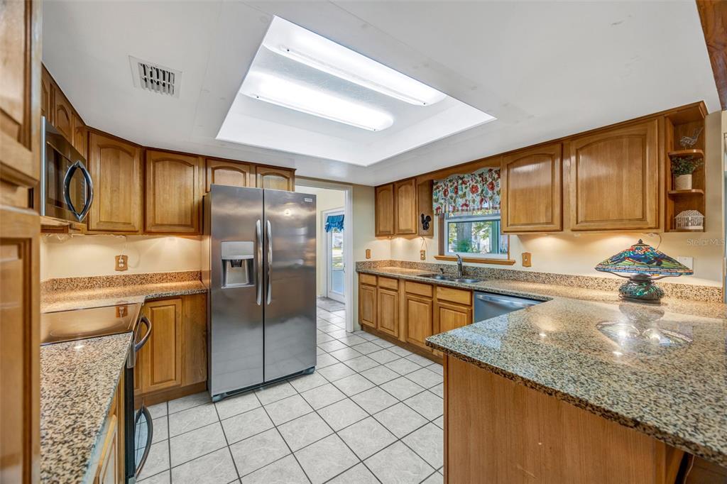 609 King Henry Court Seffner, FL 33584 - Photo 9 of 42 a kitchen with stainless steel appliances granite countertop a refrigerator a stove and a sink