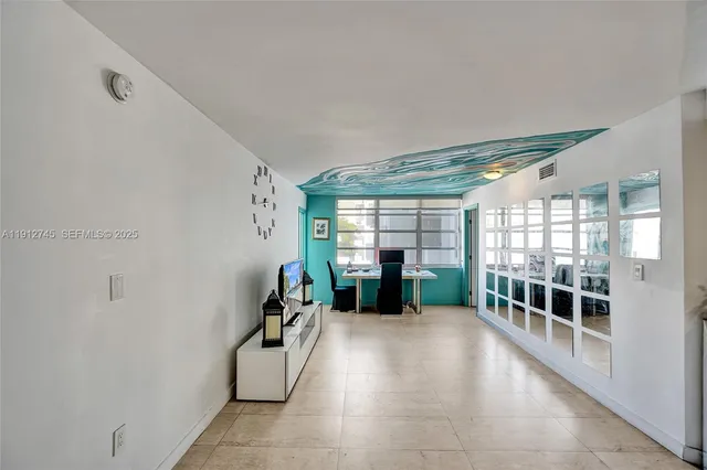 a view of a big room with windows and kitchen view