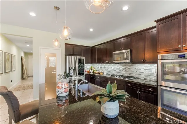 a kitchen with stainless steel appliances granite countertop a stove a refrigerator and a cabinets