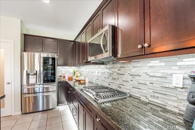 a kitchen with a refrigerator and a view of living room
