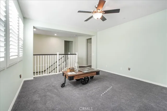 a spacious bedroom with a bed a couch and potted plant on the dresser