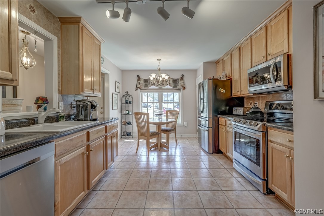 1402 Quiet Lake Loop Midlothian, VA 23114 - Photo 13 of 50 a kitchen with stainless steel appliances granite countertop a stove top oven a sink dishwasher a dining table and chairs with wooden floor