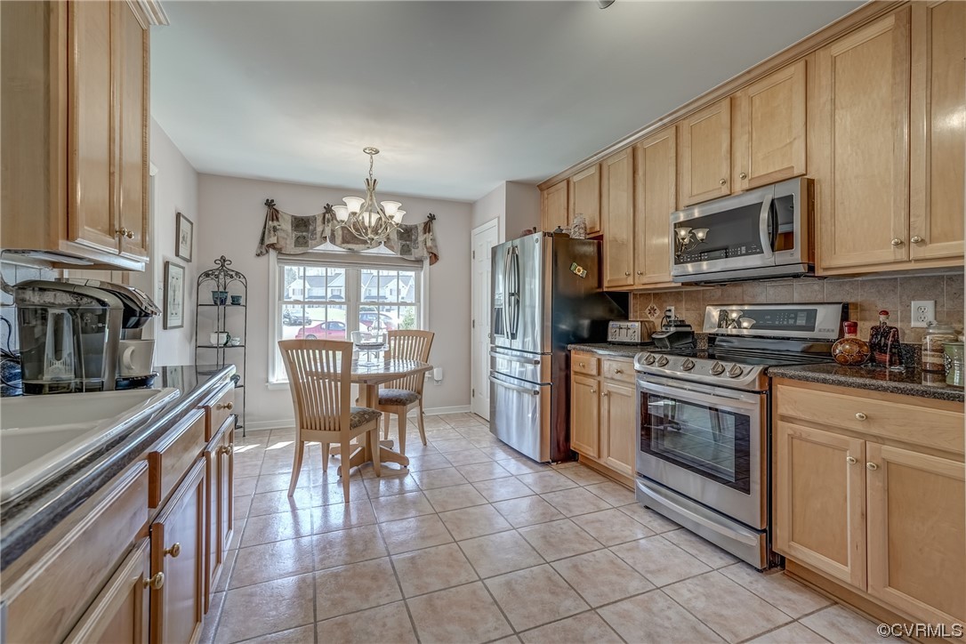 1402 Quiet Lake Loop Midlothian, VA 23114 - Photo 15 of 50 a kitchen with stainless steel appliances granite countertop a stove top oven a sink dishwasher a dining table and chairs with wooden floor