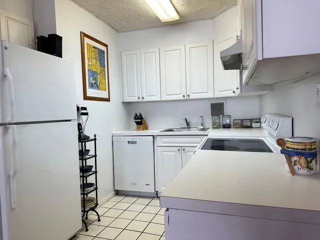 a kitchen with a refrigerator and white cabinets
