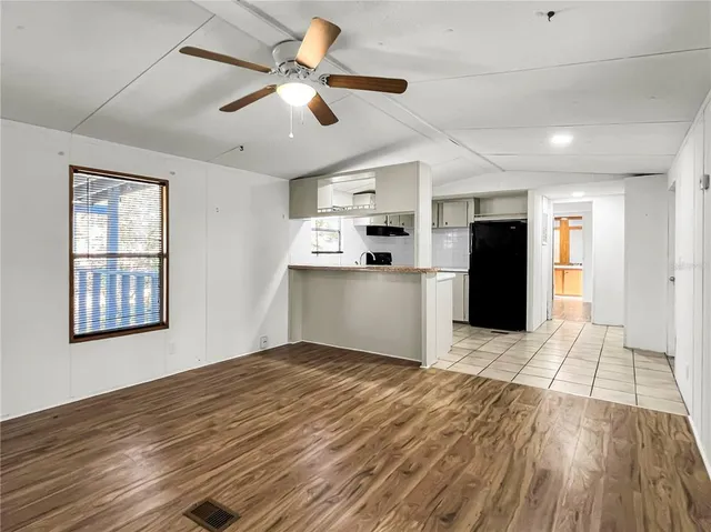 a view of empty room with wooden floor and window
