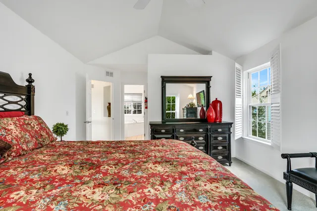 a bedroom with a bed and a flat tv screen on the dresser