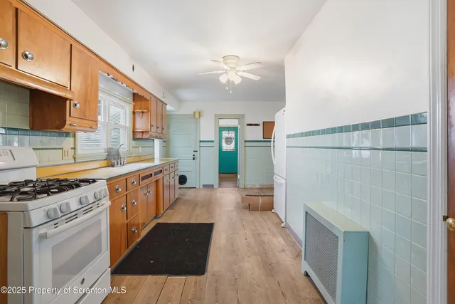 a kitchen with granite countertop a refrigerator and a stove top oven