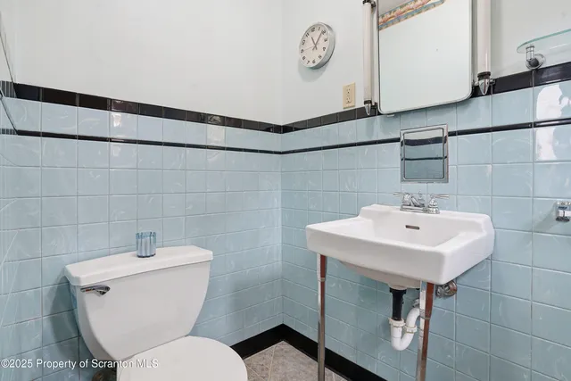 a bathroom with a toilet a sink and a mirror