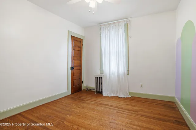 an empty room with wooden floor and closet