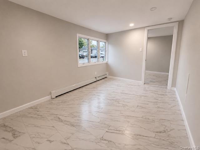 321 Sherbrooke Road Lindenhurst, NY 11757 - Photo 17 of 21 Bright, open living space featuring newly installed wood-finish flooring with marble-look detailing, recessed ceiling lighting, and large multi-pane windows providing natural light