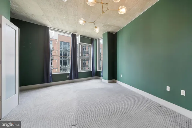 an empty room with windows and closet