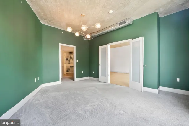 an empty room with a chandelier and a chandelier fan