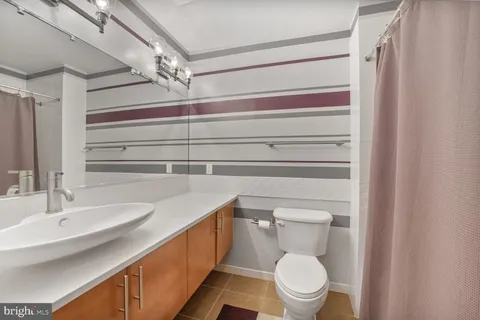 a bathroom with a sink a toilet and a mirror