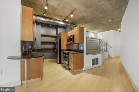 a kitchen with stainless steel appliances kitchen island granite countertop a stove and a refrigerator