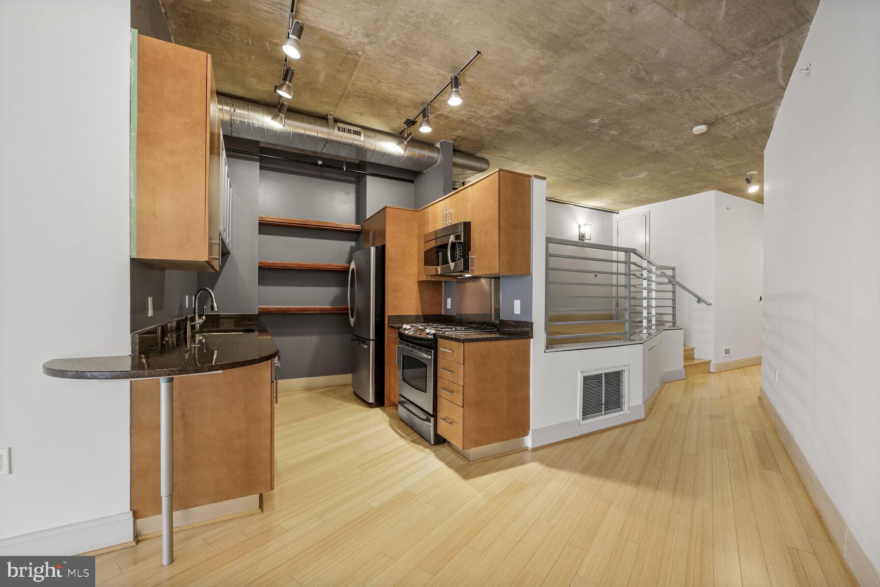 929 Florida Avenue Northwest, Unit 4008 Washington, DC 20001 - Photo 5 of 33 a kitchen with stainless steel appliances kitchen island granite countertop a stove and a refrigerator