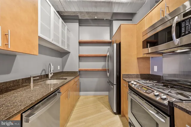 a kitchen with granite countertop stainless steel appliances and wooden cabinets