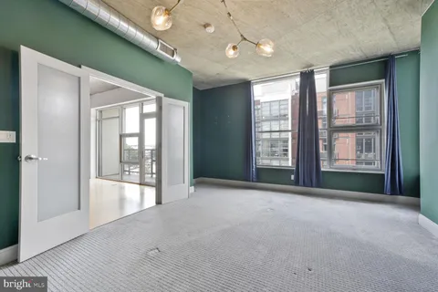a view of an empty room with glass door and balcony