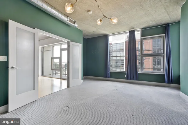 a view of an empty room with glass door and balcony