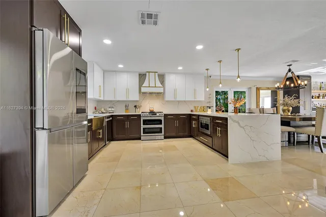 a large kitchen with stainless steel appliances lots of counter top space and appliances