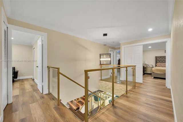 a view of a hallway with wooden floor and furniture