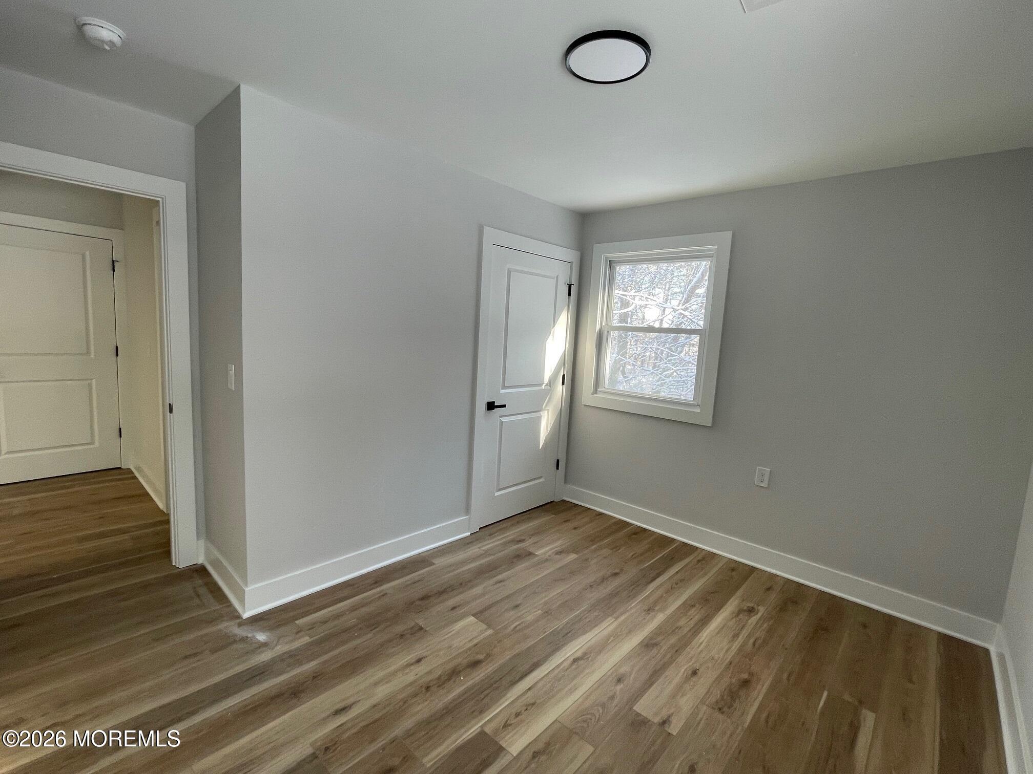 14 Churchill Road, Unit 71 Whiting, NJ 08759 - Photo 11 of 18 an empty room with wooden floor and windows