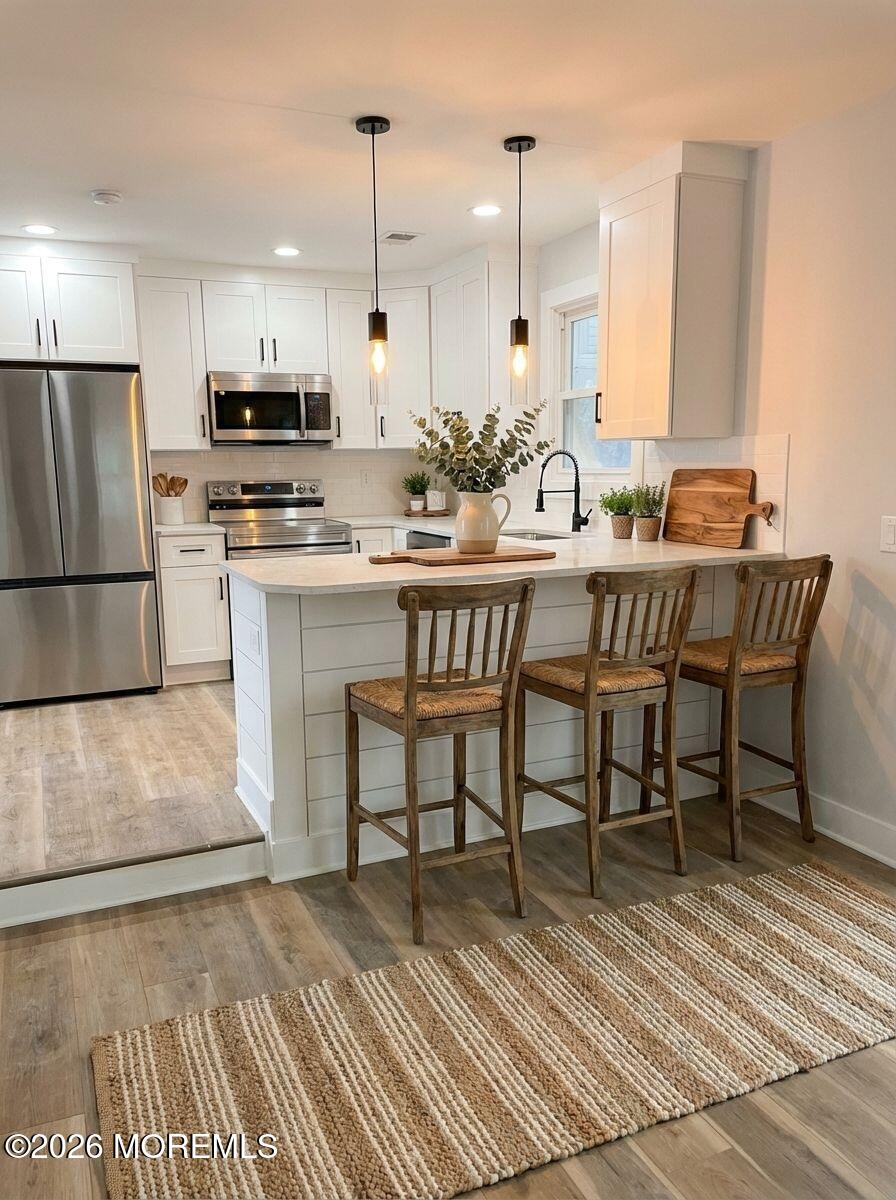 14 Churchill Road, Unit 71 Whiting, NJ 08759 - Photo 5 of 18 a kitchen with stainless steel appliances a dining table chairs microwave and sink