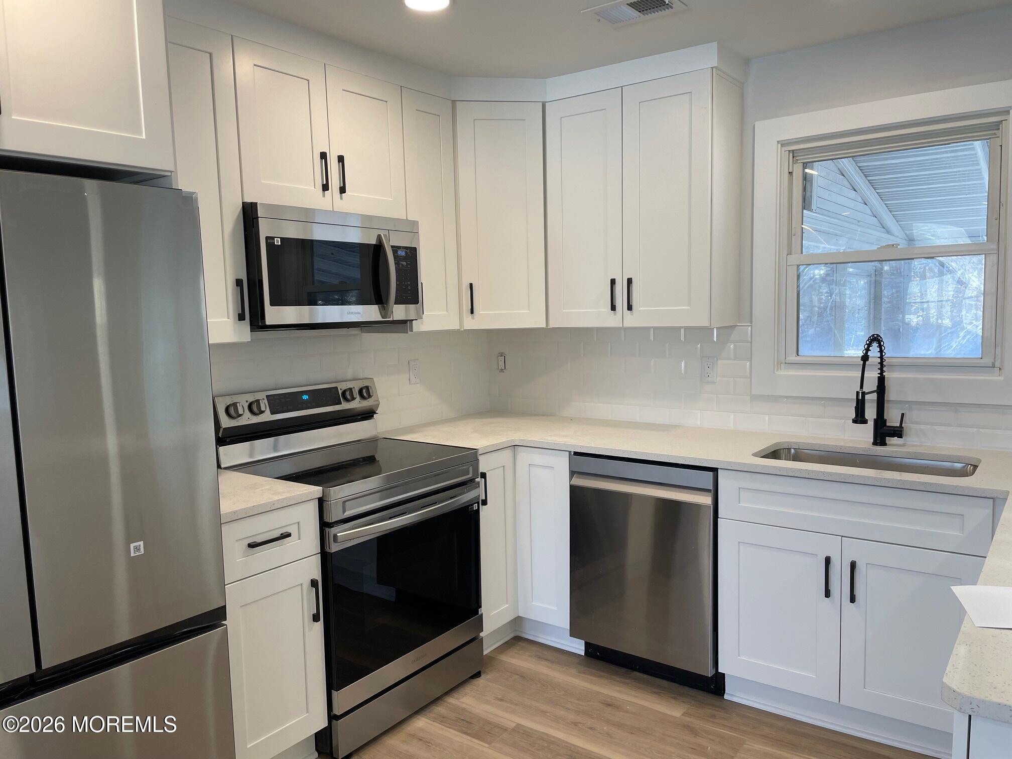 14 Churchill Road, Unit 71 Whiting, NJ 08759 - Photo 7 of 18 a kitchen with white cabinets and stainless steel appliances
