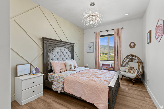 3111 South 1250 West Logan, UT 84321 - Photo 21 of 51 Feature wall with geometric wood paneling, wood-finish flooring, and a contemporary chandelier