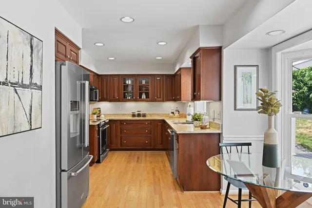 a kitchen with stainless steel appliances granite countertop a refrigerator and a stove top oven