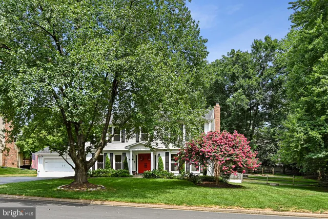 a front view of a house with a garden and trees