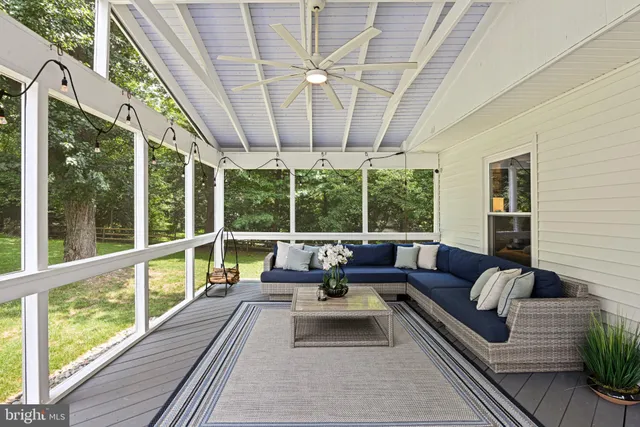 a view of a hallway with wooden floor and a bathroom