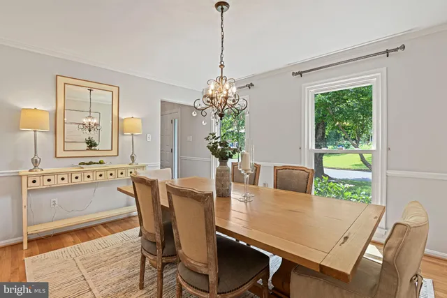 a dining room with furniture a potted plant and a chandelier