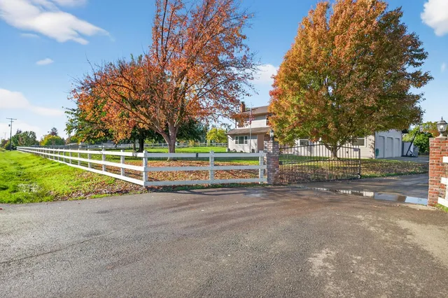 a front view of a house with a yard and trees