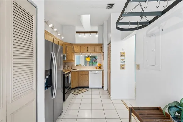 a kitchen with stainless steel appliances a refrigerator and a potted plant
