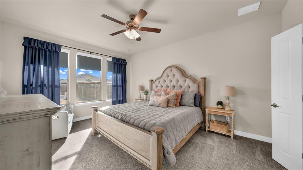 2429 Goodnight Ranch Drive Weatherford, TX 76087 - Photo 17 of 32 a bedroom with a large bed and a chandelier