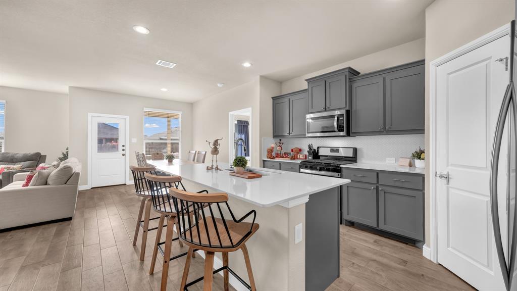 2429 Goodnight Ranch Drive Weatherford, TX 76087 - Photo 4 of 32 a kitchen with a table chairs refrigerator and cabinets
