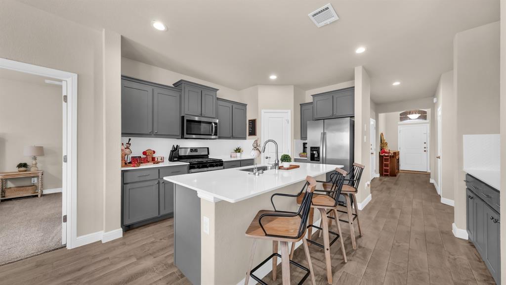 2429 Goodnight Ranch Drive Weatherford, TX 76087 - Photo 6 of 32 a kitchen with a sink a refrigerator and a stove top oven