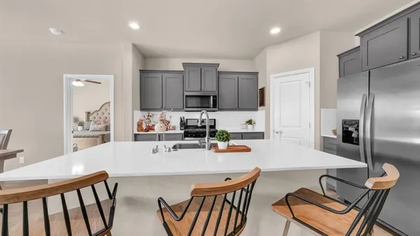 a living room with furniture and a kitchen area