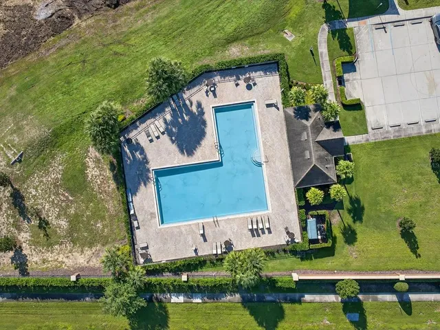 a view of a swimming pool with lawn chairs under an umbrella