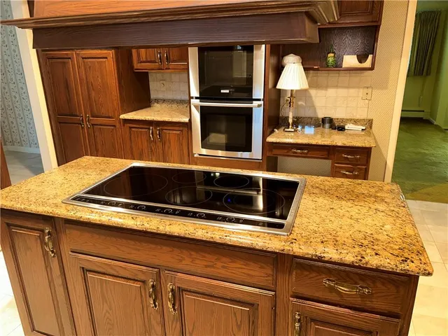 a kitchen with granite countertop a sink and a stove top oven