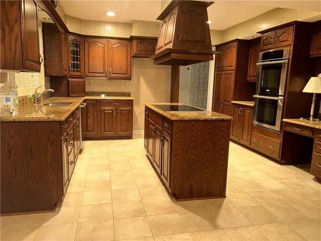 a kitchen with stainless steel appliances granite countertop a stove a sink and a refrigerator