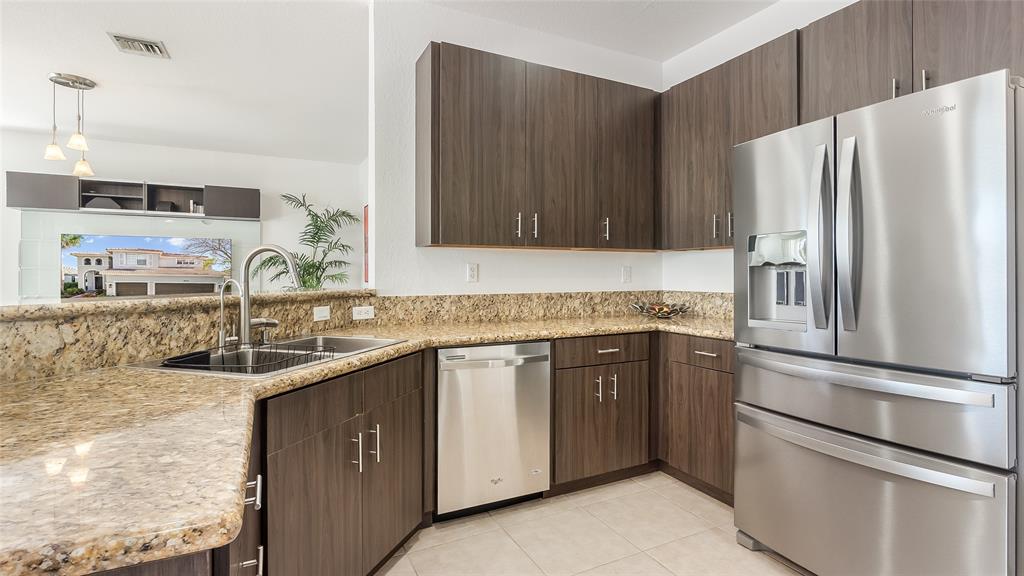 19470 Stonebrook Street Weston, FL 33332 - Photo 13 of 44 a kitchen with stainless steel appliances granite countertop a refrigerator and a sink