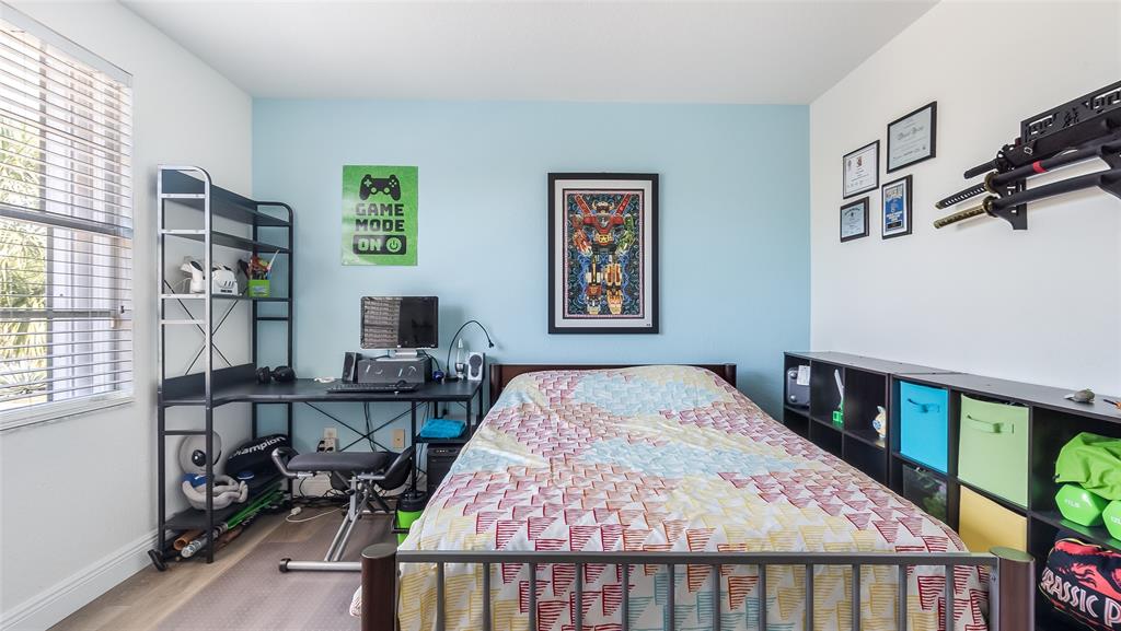 19470 Stonebrook Street Weston, FL 33332 - Photo 35 of 44 a bedroom with a bed a dresser and book shelf