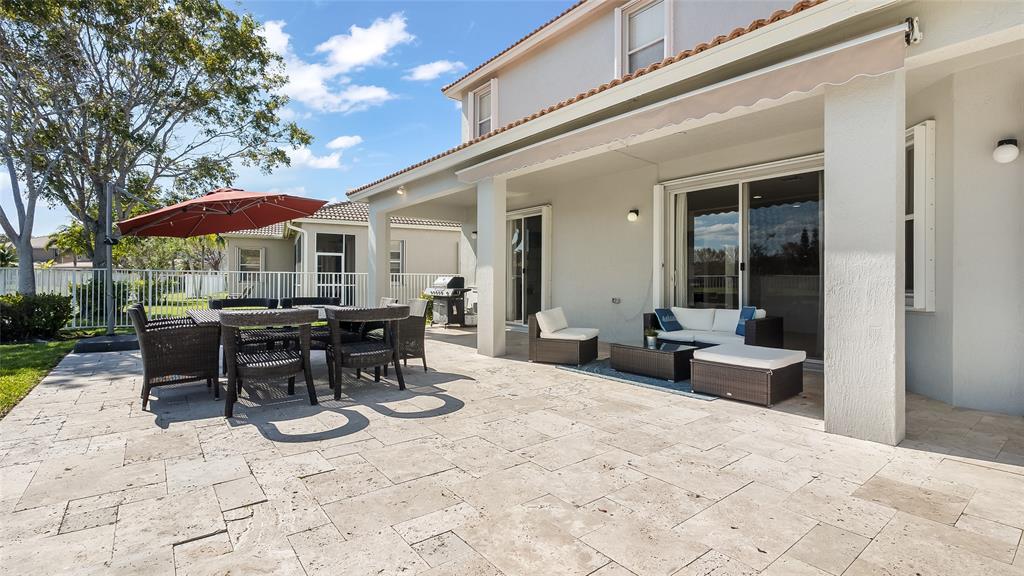 19470 Stonebrook Street Weston, FL 33332 - Photo 40 of 44 a view of a patio with table and chairs potted plants and a large tree