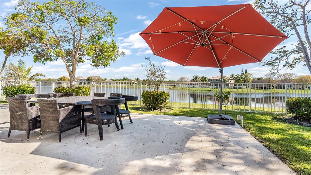 19470 Stonebrook Street Weston, FL 33332 - Photo 41 of 44 an outdoor space with furniture and umbrella
